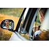 Pretty, young woman  driving her car - reflection in the side mirror (shallow DOF; color toned image)