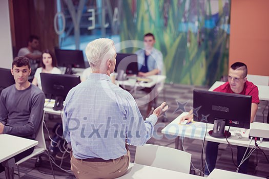 handsome mature teacher and students in computer lab classroom handsome mature teacher and students in computer lab classroom