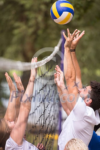 group of young friends playing Beach volleyball in a beautiful nature on the bank of the river group of young friends playing Beach volleyball in a beautiful nature on the bank of the river