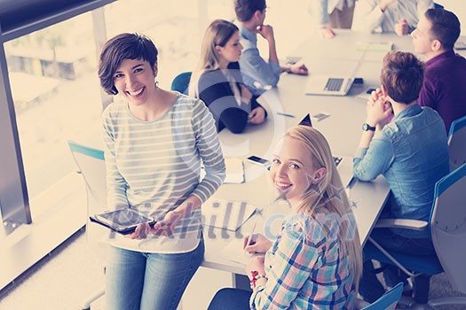 Business Women Using Digital Tablet in Busy Office