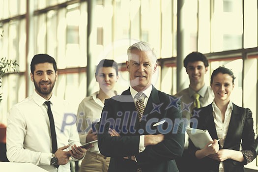 portrait of senior businessman as leader at modern bright office interior, young people group in background as team portrait of senior businessman as leader at modern bright office interior, young people group in background as team