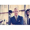 portrait of handsome senior business man with grey hait at modern bright office interior