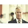 portrait of handsome senior business man with grey hait at modern bright office interior