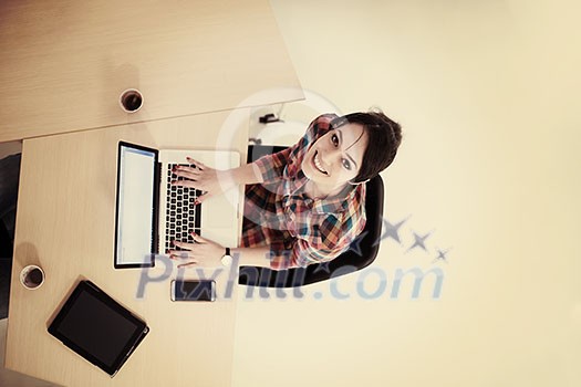 top view of young business woman working on laptop computer in modern bright startup office interior top view of young business woman working on laptop computer in modern bright startup office interior