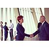partnership concept with senior  business man and woman make hand shake and take agreement in modern office interior