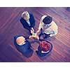 business people group assembling jigsaw puzzle and represent team support and help concept, top view perspective at modern bright office interior