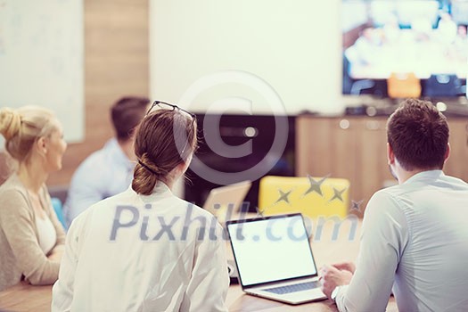 Group of a young business people discussing business plan at modern startup office building Group of a young business people discussing business plan at modern startup office building