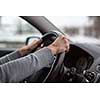 Driver's hands driving a car on a highway (color toned image; shallow DOF)