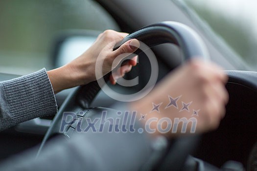 Driver's hands driving a car on a highway (color toned image; shallow DOF) Driver's hands driving a car on a highway (color toned image; shallow DOF)