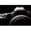 Professional modern DSLR camera low key image - Modern DSLR camera with a very wide aperture lens on