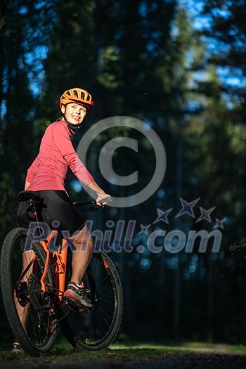 Pretty, young woman biking on a mountain bike enjoying healthy active lifestyle outdoors in summer (shallow DOF) Pretty, young woman biking on a mountain bike enjoying healthy active lifestyle outdoors in summer (shallow DOF)