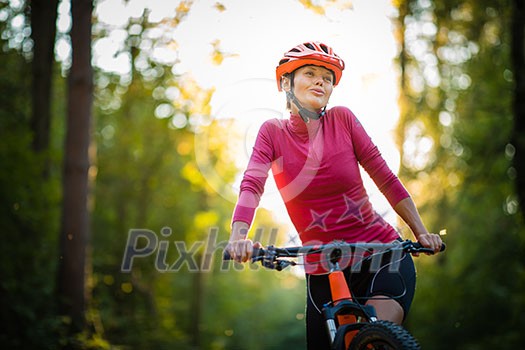 Pretty, young woman biking on a mountain bike enjoying healthy active lifestyle outdoors in summer (shallow DOF) Pretty, young woman biking on a mountain bike enjoying healthy active lifestyle outdoors in summer (shallow DOF)