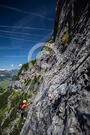 Pretty, female climber on a via ferrata - climbing on a rock in Swiss Alps Pretty, female climber on a via ferrata - climbing on a rock in Swiss Alps