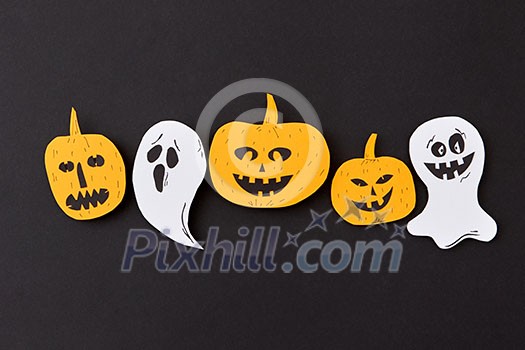 Creative handmade pattern with paper horrible smiling spirits and ghosts and laughing pumpkin on a black paper background, place under text. Flat lay. Creative handmade pattern with paper horrible smiling spirits and ghosts and laughing pumpkin on a black paper background, place under text. Flat lay.