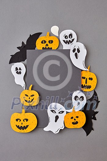 Creative handcraft application with terrible spirits smiling and laughing the pumpkins, black bats on a gray background, copy space. Halloween concept. Flat lay. Creative handcraft application with terrible spirits smiling and laughing the pumpkins, black bats on a gray background, copy space. Halloween concept. Flat lay.