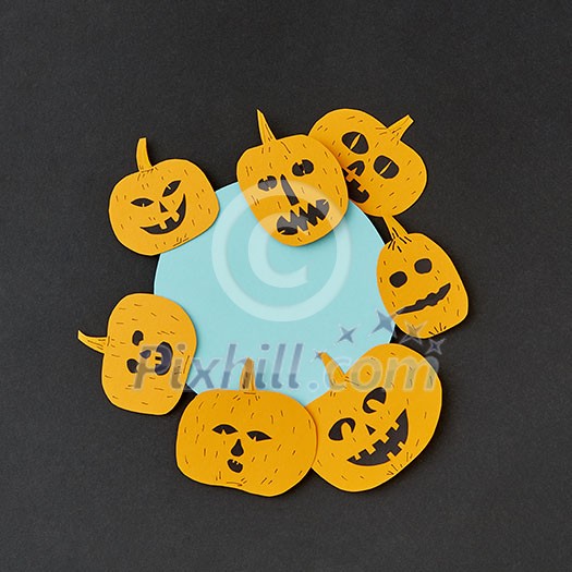 Creative card for invitation for Halloween with handmade paper round frame and yellow smiling scary pumpkins on a black paper, place under text. Flat lay Creative card for invitation for Halloween with handmade paper round frame and yellow smiling scary pumpkins on a black paper, place under text. Flat lay