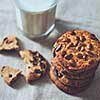 Traditional Christmas treat for Santa - homemade oatmeal cookies with peanut and glass of milk on a textile background.