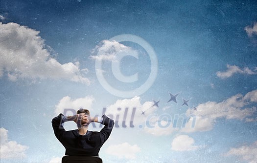 Rear view of businessman sitting on chair with hands on head Rear view of businessman sitting on chair with hands on head