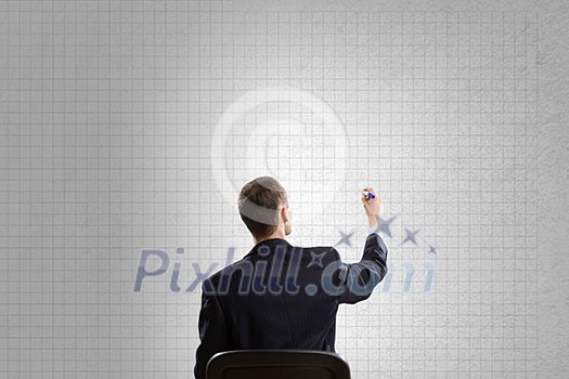 Rear view of businessman in chair writing on wall Rear view of businessman in chair writing on wall