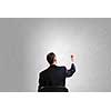 Rear view of businessman in chair writing on wall