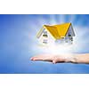 Human hands holding model of dream house