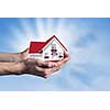 Human hands holding model of dream house