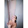 Woman taking a long hot shower washing her hair in a modern design bathroom