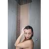 Woman taking a long hot shower washing her hair in a modern design bathroom