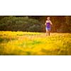 Young woman running outdoors on a lovely sunny summer evening (shallow DOF; color toned image)