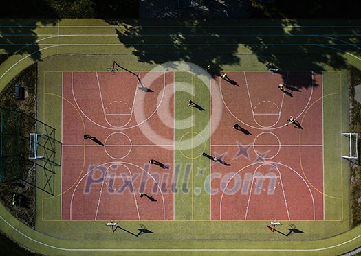 Aerial view of a soccer pitch with people playing soccer on it - in warm morning sun, casting long shadows Aerial view of a soccer pitch with people playing soccer on it - in warm morning sun, casting long shadows