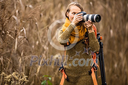 Pretty, female photographer taking pictures outdoor on a lovely autumn day - shallow DOF, color toned image Pretty, female photographer taking pictures outdoor on a lovely autumn day - shallow DOF, color toned image