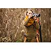 Pretty, female photographer taking pictures outdoor on a lovely autumn day - shallow DOF, color toned image