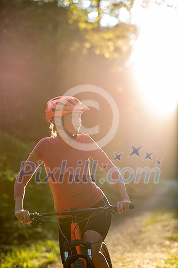 Pretty, young woman biking on a mountain bike enjoying healthy active lifestyle outdoors in summer (shallow DOF) Pretty, young woman biking on a mountain bike enjoying healthy active lifestyle outdoors in summer (shallow DOF)