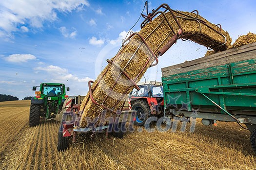 Tractors working on a farm field, - agricultural machines at work Tractors working on a farm field, - agricultural machines at work