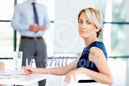 Businesswoman sitting and smiling at camera Businesswoman sitting and smiling at camera
