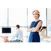 Young businesswoman standing in office with her collegue on the background