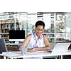 Portrait of a young business woman working on a laptop in a office