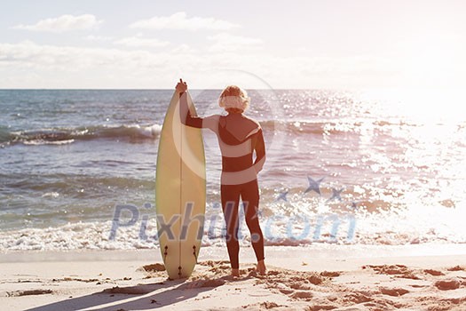A surfer with his surfboard at the beach A surfer with his surfboard at the beach