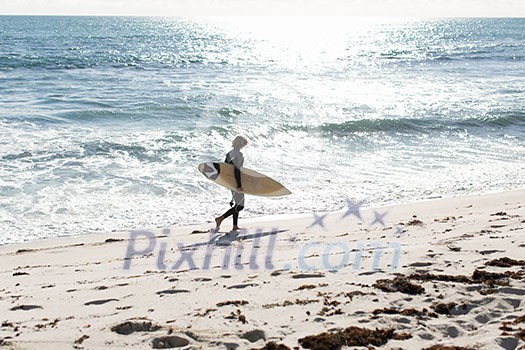 A surfer with his surfboard at the beach A surfer with his surfboard at the beach