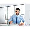 Young businessman in office sitting and smiling