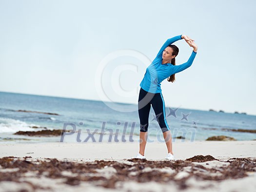 Sporty young woman stretching on the sea coast Sporty young woman stretching on the sea coast