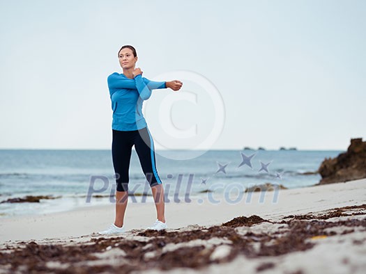 Sporty young woman stretching on the sea coast Sporty young woman stretching on the sea coast