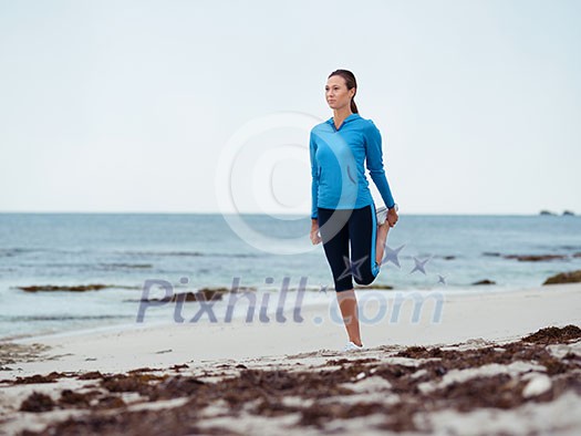 Sporty young woman stretching on the sea coast Sporty young woman stretching on the sea coast