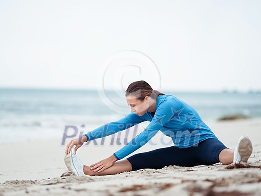 Sporty young woman exercising on the sea coast Sporty young woman exercising on the sea coast