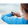 Sporty young woman looking at her watches