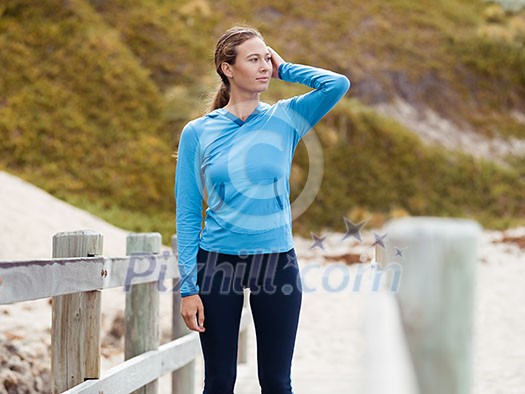 Sporty young woman standing not far from the beach Sporty young woman standing not far from the beach