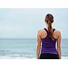 Sporty young woman standing on the sea coast