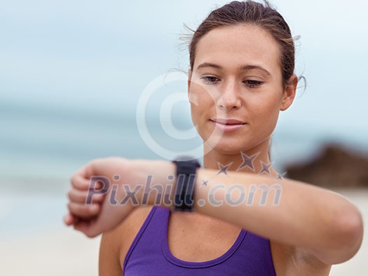 Sporty young woman looking at her wristwatch Sporty young woman looking at her wristwatch