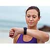 Sporty young woman looking at her wristwatch