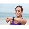 Sporty young woman looking at her wristwatch